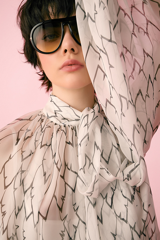 A white chiffon blouse with an author's print